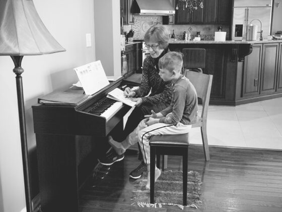 My mom teaching 2 of my sons on the piano